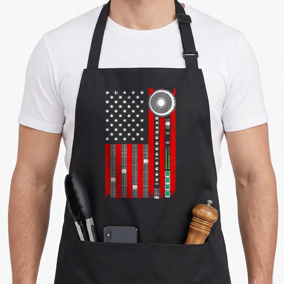 Producer american flag apron - Distressed US flag with red audio fader stripes and grey mixing wheel on right side — shown on a black cotton canvas apron against a white background