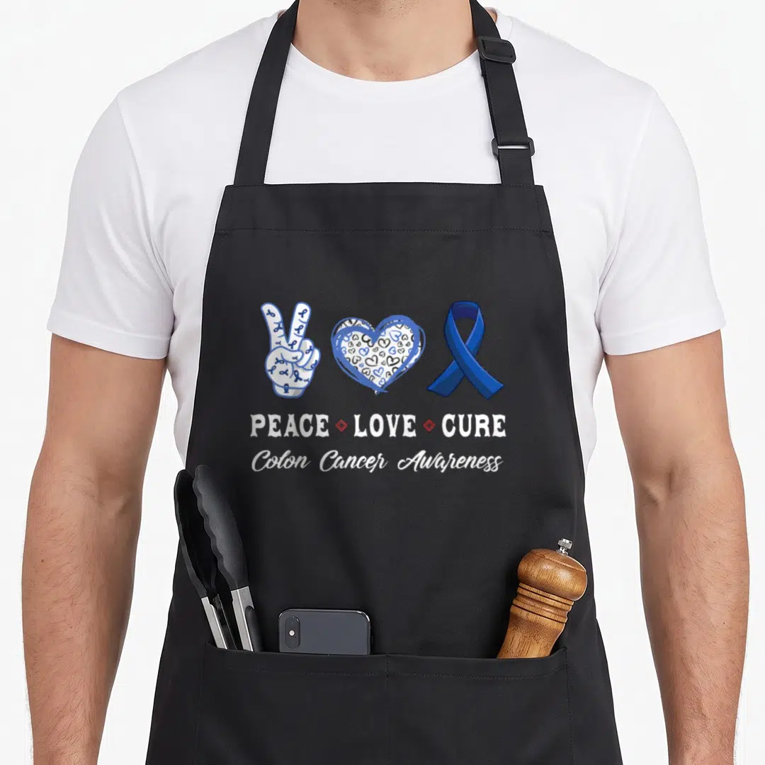 Peace colon cancer awareness apron - Blue ribbon peace sign heart and Cure text in cartoon style — shown on a black cotton canvas apron against a white background