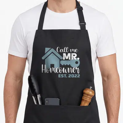 Call mr apron - Blue house and key silhouette with Call me MR. Homeowner EST. 2022 text — shown on a black cotton canvas apron against a white background