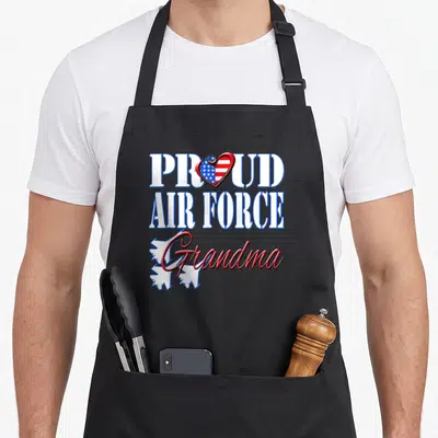 Air grandma apron - PROUD AIR FORCE Grandma text with patriotic heart and two white jets — shown on a black cotton canvas apron against a white background