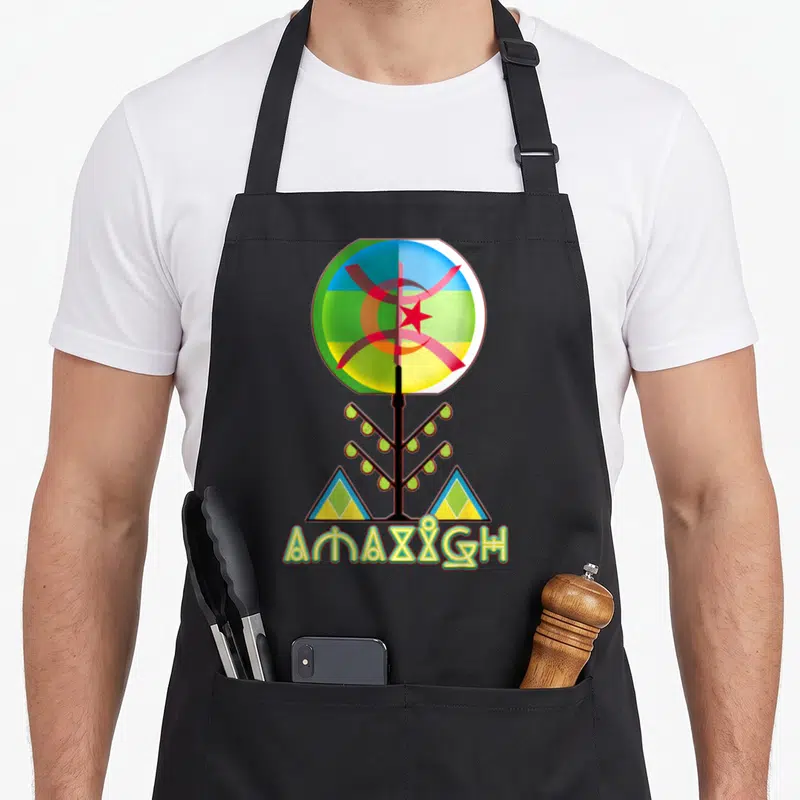 Amazigh tree aprons - Circular symbol with red star and crescent above stylized tree and two triangles — shown on a black cotton canvas apron against a white background