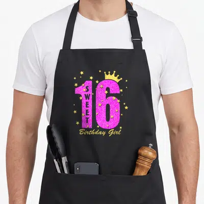16th sixteen birthday apron - Pink glittery number 16 with vertical SWEET text, gold crown, and scattered gold stars — shown on a black cotton canvas apron against a white background