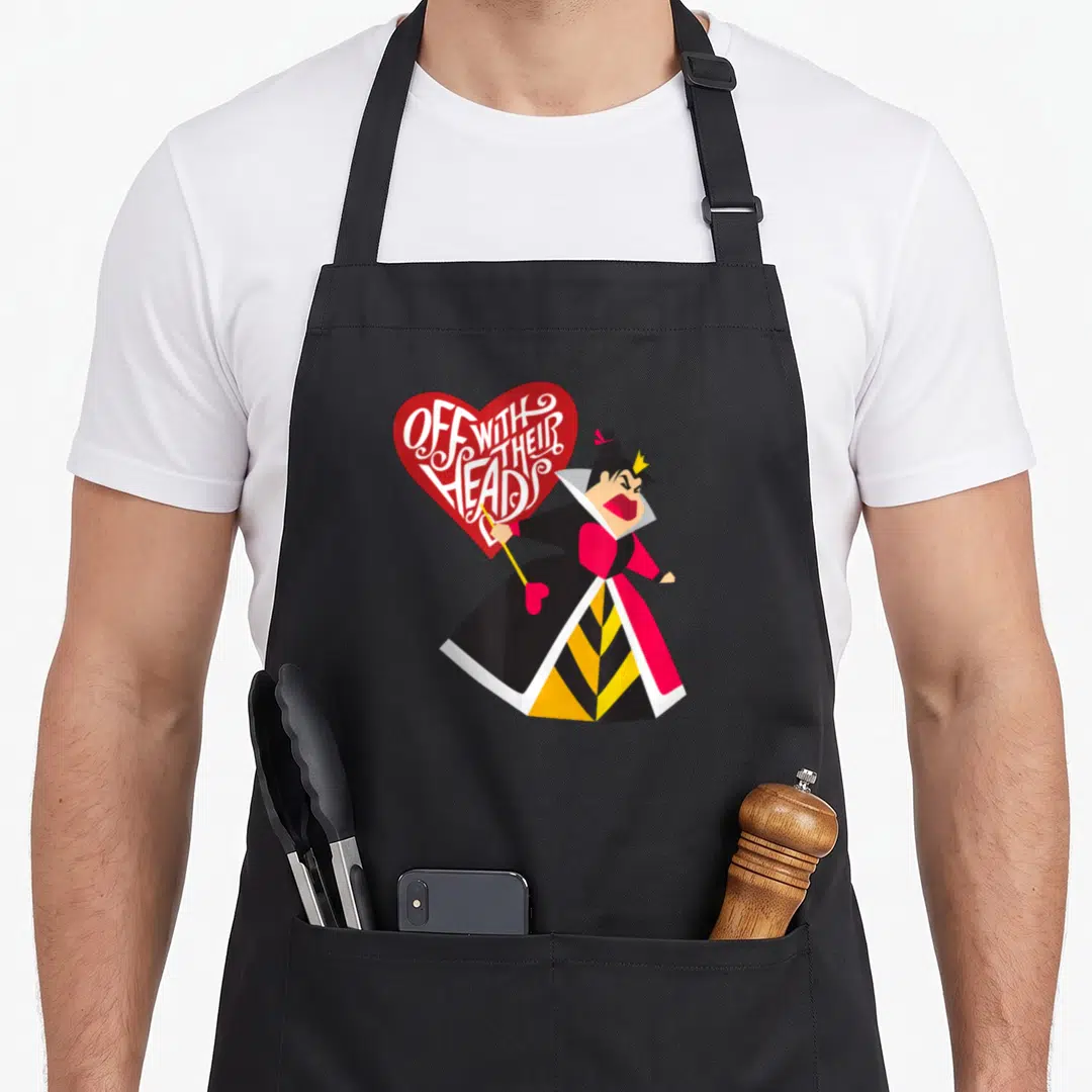 Queen alice wonderland apron - Queen of Hearts holding scepter next to red heart with OFF WITH THEIR HEADS text — shown on a black cotton canvas apron against a white background