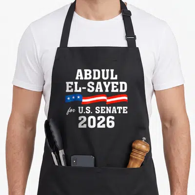 Abdul senator apron - ABDUL EL-SAYED for U.S. SENATE 2026 text with red white blue star ribbon — shown on a black cotton canvas apron against a white background