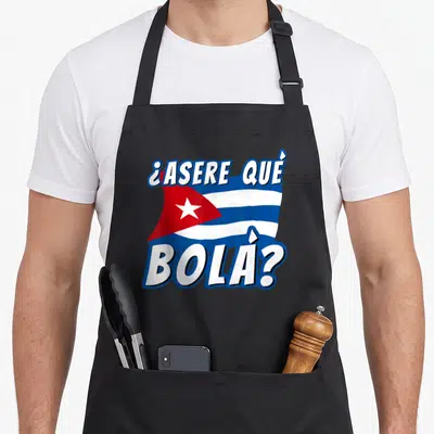 Havana cuban boy apron - Cartoon Cuban flag in blue white and red with ¿ASERE QUÉ, BOLA? text overlapping top and bottom — shown on a black cotton canvas apron against a white background
