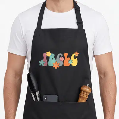 Ibclc floral apron - Bubbly IBCLC text surrounded by five pink, blue, orange, and yellow cartoon flowers — shown on a black cotton canvas apron against a white background