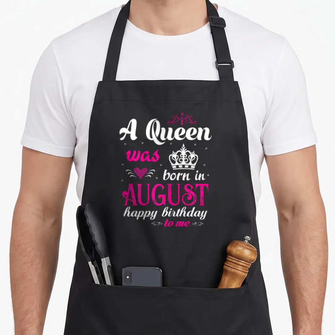 Queen august birthday apron - White and pink text A Queen was born in August happy birthday to me with crown heart — shown on a black cotton canvas apron against a white background