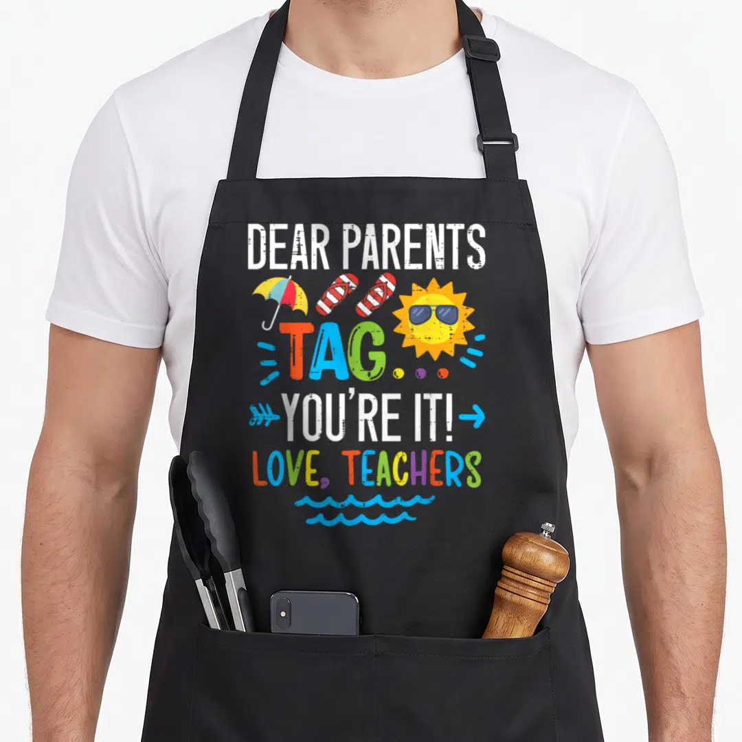 Teacher tag apron - DEAR PARENTS TAG YOU'RE IT text with sun umbrella flip flops and waves in colorful typography — shown on a black cotton canvas apron against a white background