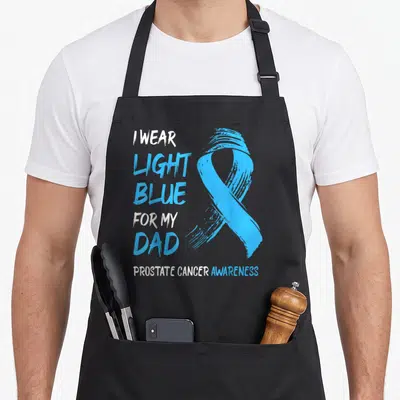 Blue prostate cancer awareness apron - Light blue awareness ribbon with stacked text I wear light blue for my dad — shown on a black cotton canvas apron against a white background