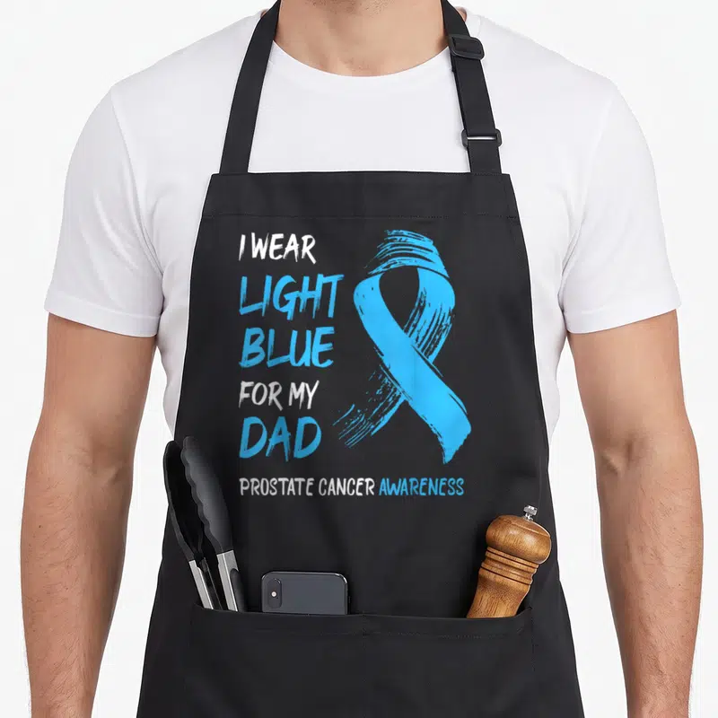 Blue prostate cancer awareness apron - Light blue awareness ribbon with stacked text I wear light blue for my dad — shown on a black cotton canvas apron against a white background