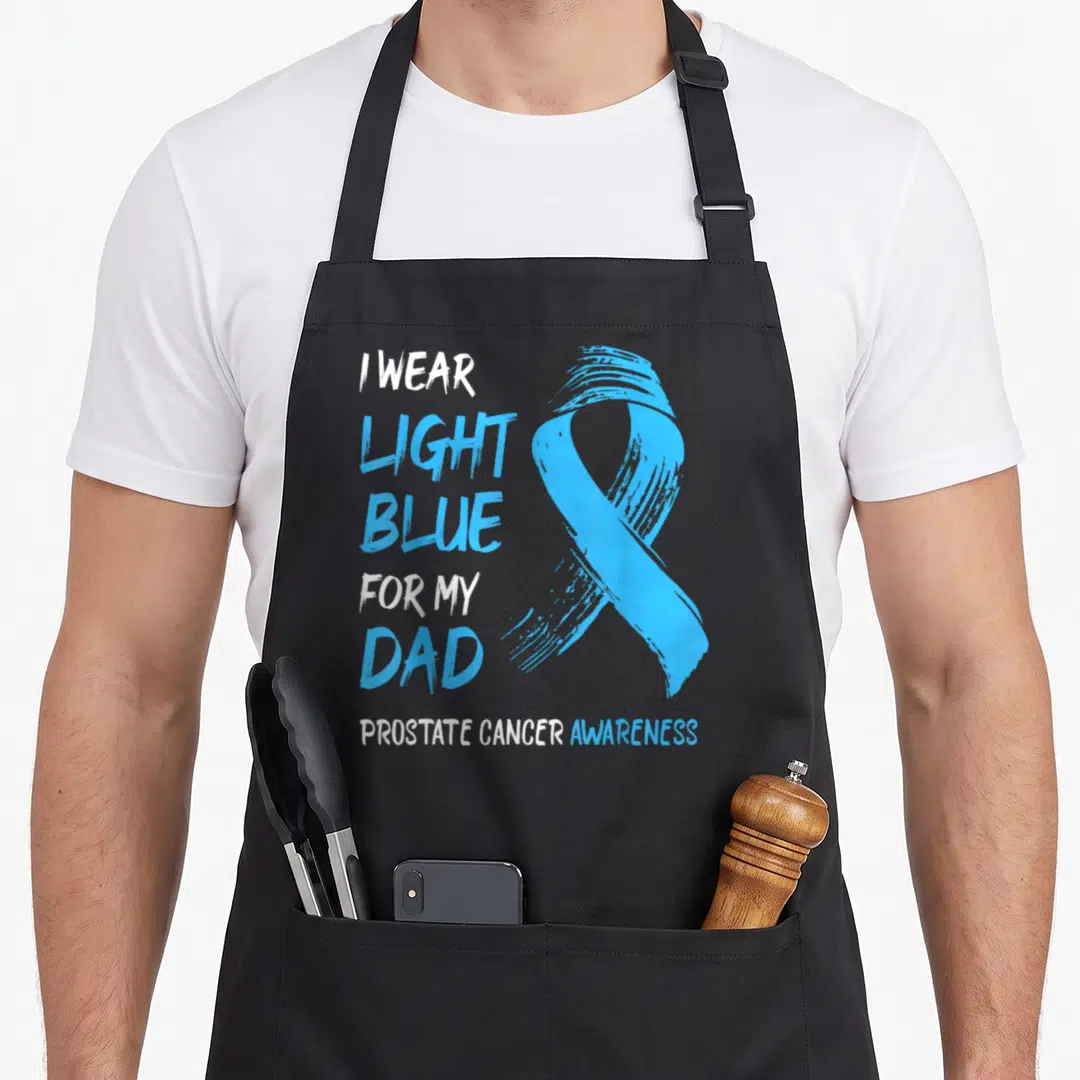 Blue prostate cancer awareness apron - Light blue awareness ribbon with stacked text I wear light blue for my dad — shown on a black cotton canvas apron against a white background