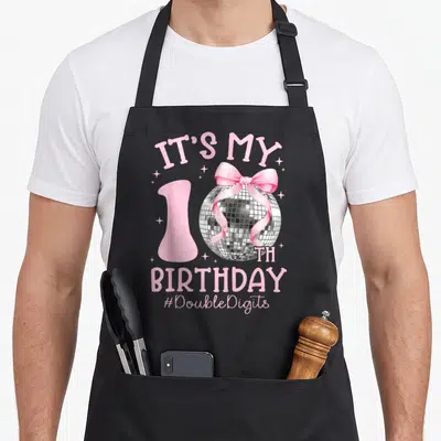Birthday bow apron - Pink 10th birthday disco ball with pink bow and DoubleDigits text — shown on a black cotton canvas apron against a white background