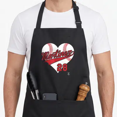 Gameday baseball apron - White heart shape made of two baseballs with red Martinez script and number 28 — shown on a black cotton canvas apron against a white background