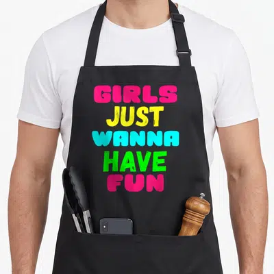 Cool general novelty apron for grilling - Stacked pink yellow cyan and green text reading GIRLS JUST WANNA HAVE FUN — shown on a black cotton canvas apron against a white background
