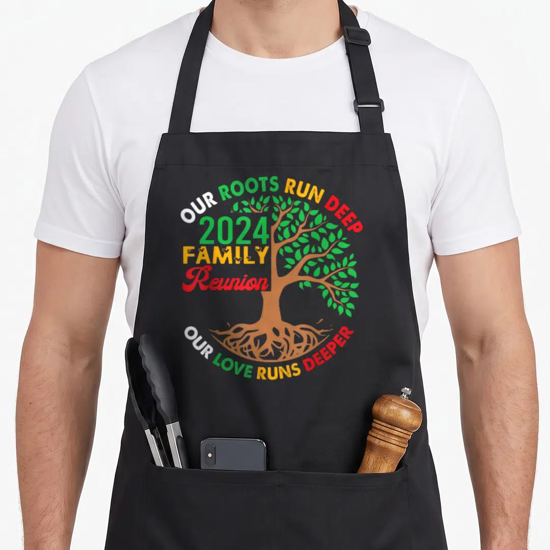 Run family reunion aprons - Cartoon tree with roots and arched text Our Roots Run Deep 2024 Family Reunion in green — shown on a black cotton canvas apron against a white background
