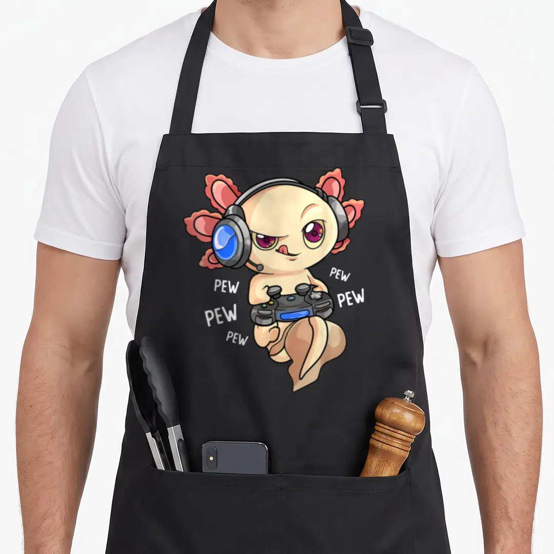 Kawaii video game apron - Peach axolotl with blue headphones holding controller surrounded by white PEW text — shown on a black cotton canvas apron against a white background
