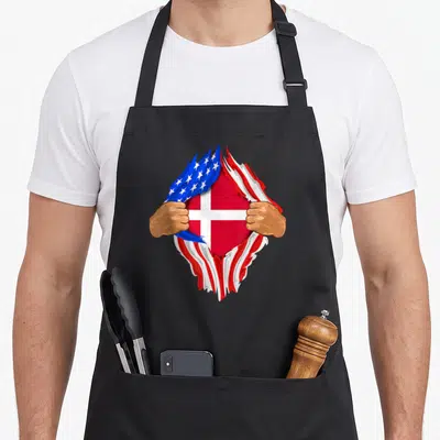 Danish blood apron - Two hands tearing open a surface to reveal a red white and blue flag design — shown on a black cotton canvas apron against a white background