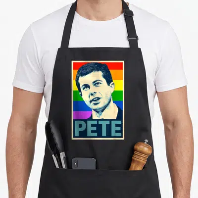 Buttigieg mayor apron - Man portrait over rainbow stripes with PETE text in dark blue block — shown on a black cotton canvas apron against a white background