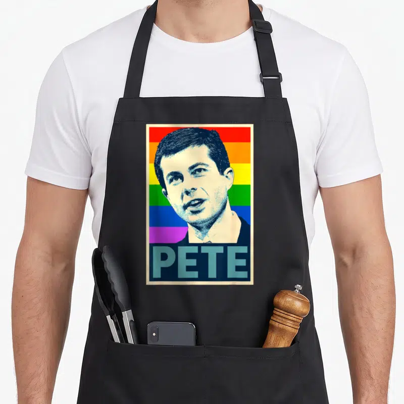 Buttigieg mayor apron - Man portrait over rainbow stripes with PETE text in dark blue block — shown on a black cotton canvas apron against a white background