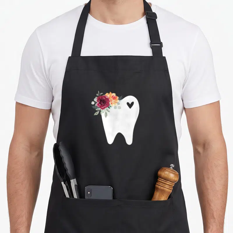 Dental pretty apron - White tooth with red orange roses and grey heart watercolor print — shown on a black cotton canvas apron against a white background