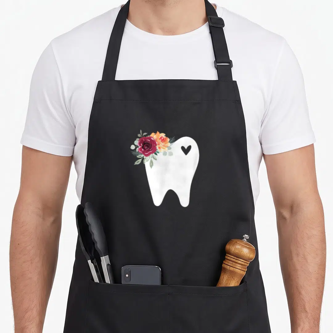 Dental pretty apron - White tooth with red orange roses and grey heart watercolor print — shown on a black cotton canvas apron against a white background