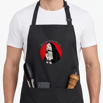Nun gothic apron - Distressed nun with gag and cuffs in red circle with text RELIGION MAKES ME GAG — shown on a black cotton canvas apron against a white background