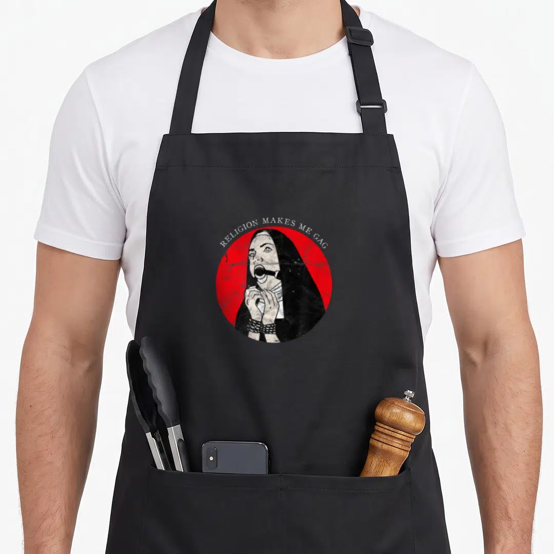 Nun gothic apron - Distressed nun with gag and cuffs in red circle with text RELIGION MAKES ME GAG — shown on a black cotton canvas apron against a white background