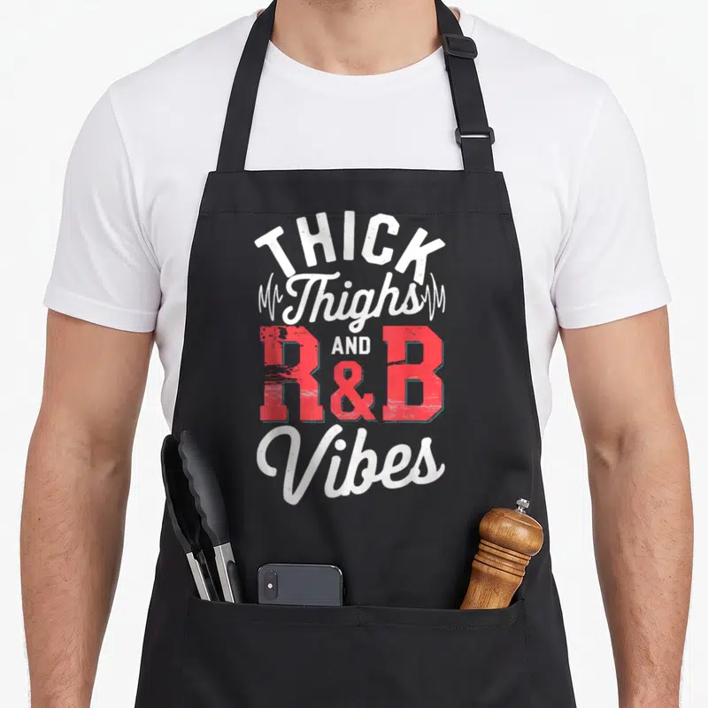 Thigh r aprons - THICK Thighs AND R&B Vibes text with heartbeat lines in white and red — shown on a black cotton canvas apron against a white background
