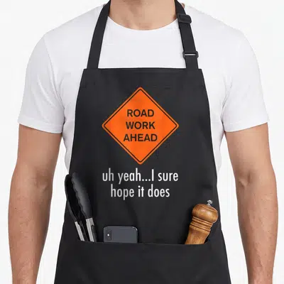 Roadwork road apron - Orange diamond sign reading ROAD WORK AHEAD with white text below — shown on a black cotton canvas apron against a white background