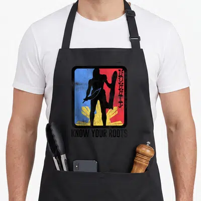 Lapu filipino pride apron - Warrior silhouette holding sword and shield over blue red yellow sun with KNOW YOUR ROOTS — shown on a black cotton canvas apron against a white background
