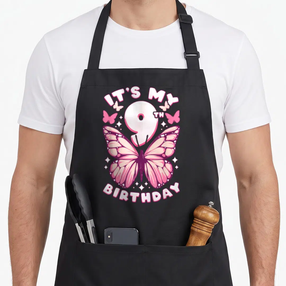 Birthday number butterfly aprons - Pink butterfly illustration with IT'S MY 9TH BIRTHDAY text and sparkles — shown on a black cotton canvas apron against a white background