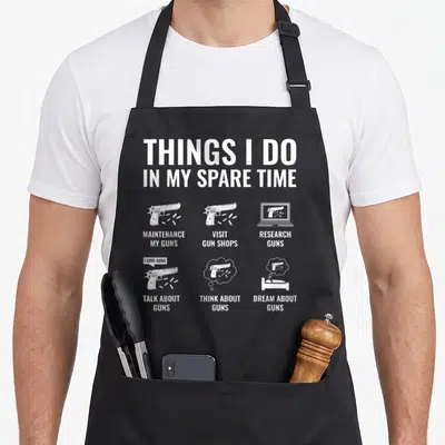 Spare gun apron - White handgun icons and text listing maintenance and shop visits — shown on a black cotton canvas apron against a white background