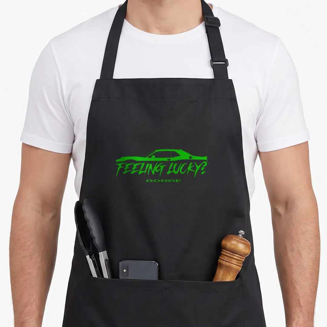 Dodge st patrick day aprons - Green car silhouette above feeling lucky and dodge text — shown on a black cotton canvas apron against a white background