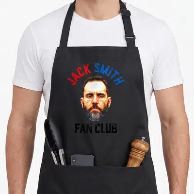 Political american flag apron - Distressed portrait of man with arched red and blue JACK SMITH text and black FAN CLUB — shown on a black cotton canvas apron against a white background