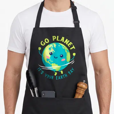 Earth animal apron - Cute cartoon Earth with GO PLANET text in blue lime green and pink — shown on a black cotton canvas apron against a white background