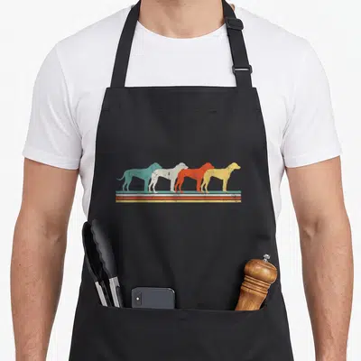 Rhodesian ridgeback dog apron - Four retro dog silhouettes in teal beige orange and yellow above three horizontal — shown on a black cotton canvas apron against a white background