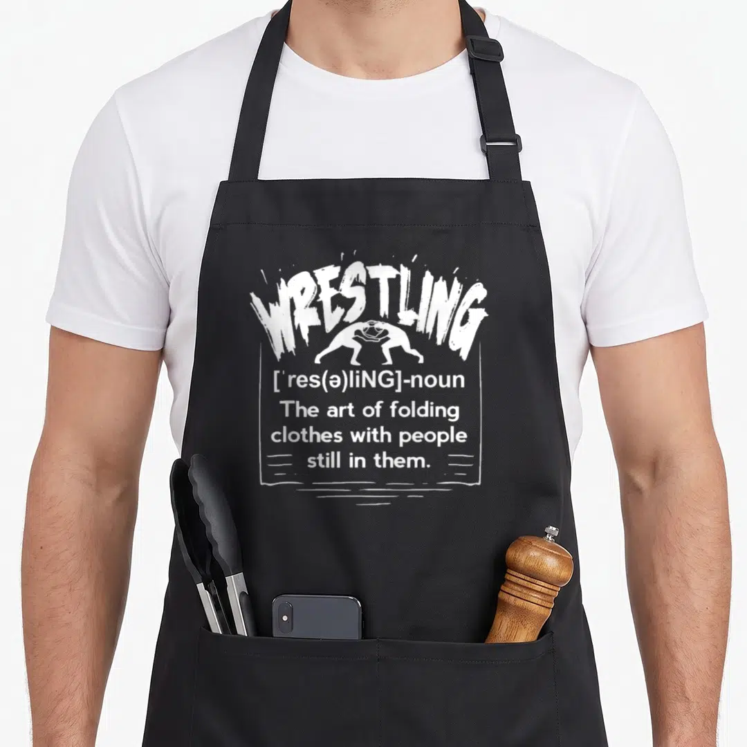 Definition wrestler wrestling apron - White distressed dictionary definition of wrestling with two grappling figures — shown on a black cotton canvas apron against a white background