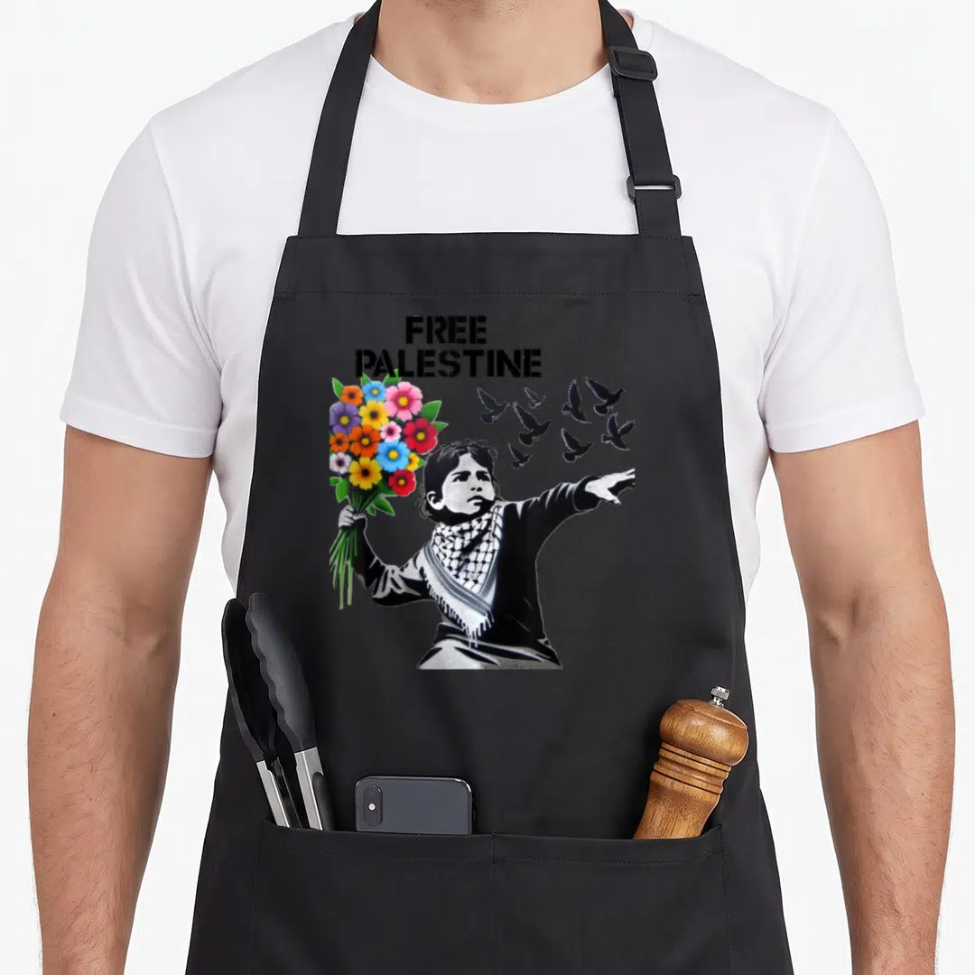 Retro free palestine apron - Child holding colorful flowers and gesturing to flying birds under stacked FREE PALESTINE — shown on a black cotton canvas apron against a white background