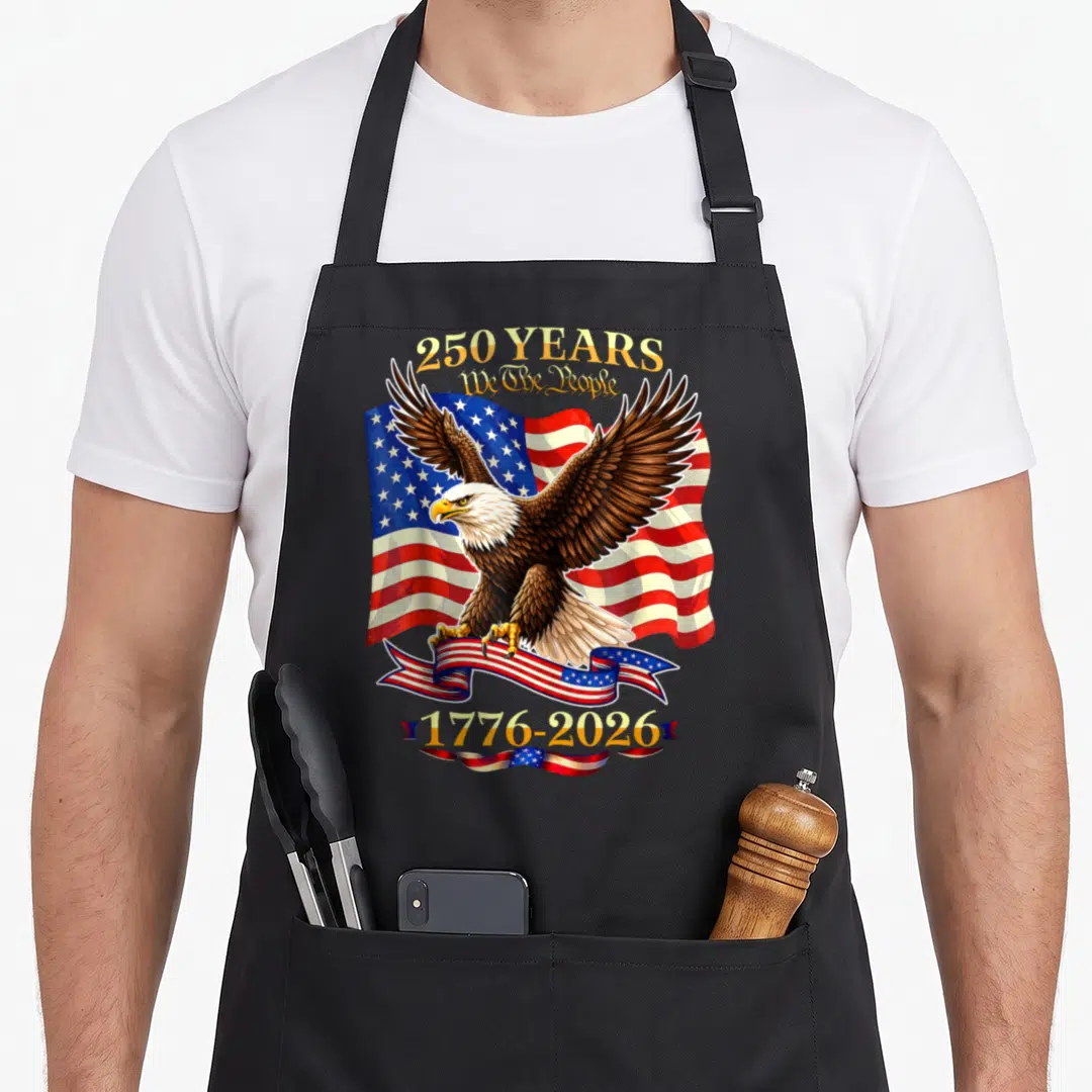 Birthday 4th of july apron - Bald eagle clutching flag ribbon with 250 YEARS text and 1776-2026 dates — shown on a black cotton canvas apron against a white background