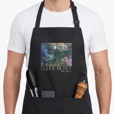 Trendy white lily apron - Rectangular water lily painting in green blue white purple with CLAUDE MONET Water Lilies — shown on a black cotton canvas apron against a white background