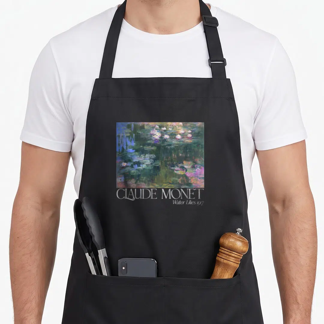 Trendy white lily apron - Rectangular water lily painting in green blue white purple with CLAUDE MONET Water Lilies — shown on a black cotton canvas apron against a white background