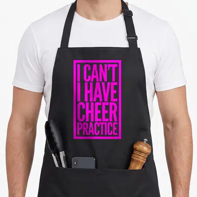 Perfect cheer apron - Pink stacked text I can't I have cheer practice inside rectangular border — shown on a black cotton canvas apron against a white background