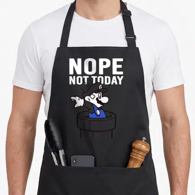 Warp not today apron - Stacked NOPE NOT TODAY text above cartoon Mario pointing left from a grey pipe — shown on a black cotton canvas apron against a white background