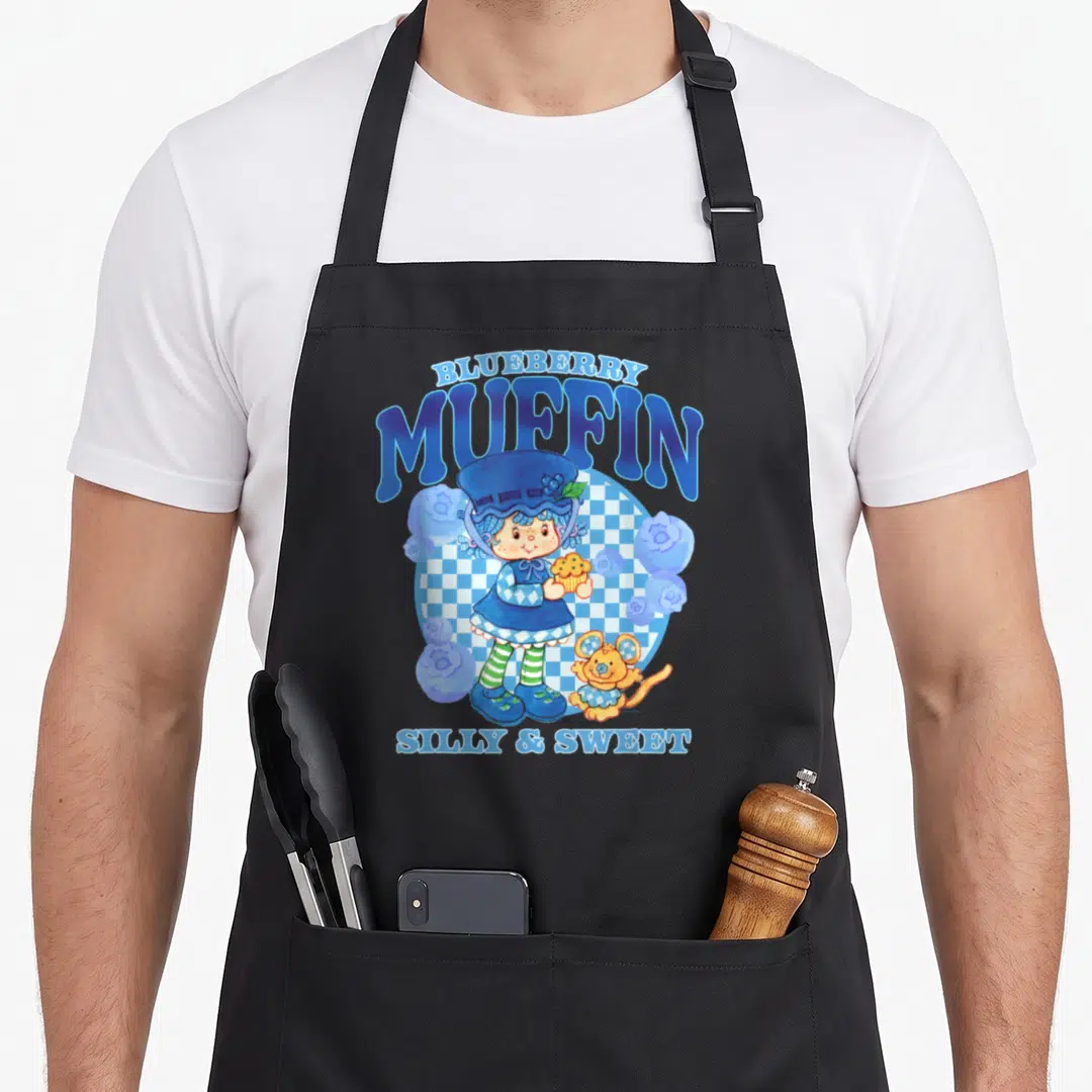 Blueberry strawberry shortcake apron - Cartoon girl holding muffin with mouse under Blueberry Muffin text on checkered — shown on a black cotton canvas apron against a white background