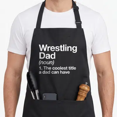 Sport wrestling apron - White stacked text defining Wrestling Dad as the coolest title a dad can have — shown on a black cotton canvas apron against a white background