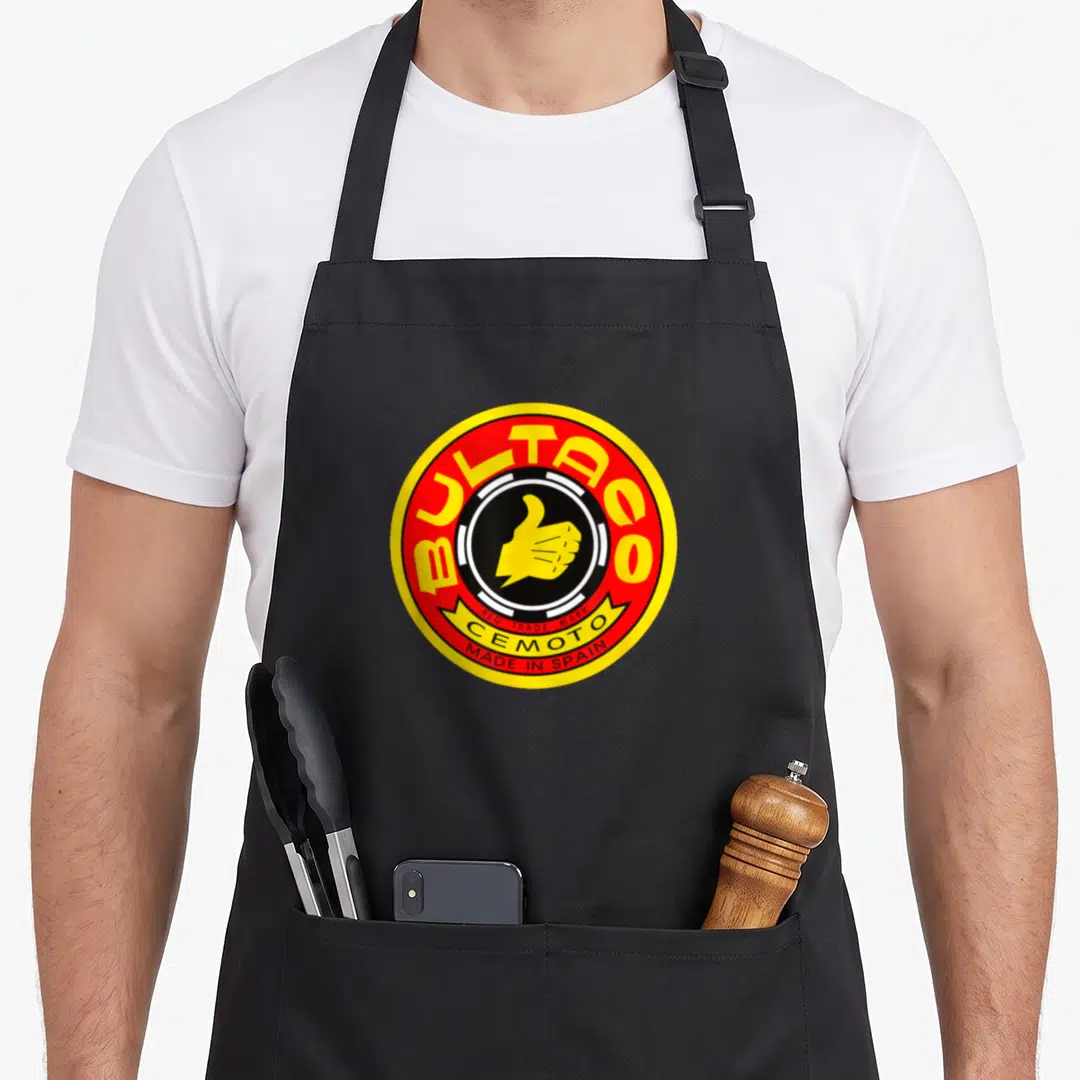 Bultaco motorcycle apron - Red and yellow circular logo with yellow thumbs up and BULTACO text — shown on a black cotton canvas apron against a white background