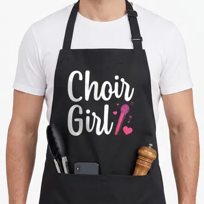 Choir singing chorus apron - Stacked white Choir Girl text beside pink microphone, hearts, and musical notes — shown on a black cotton canvas apron against a white background