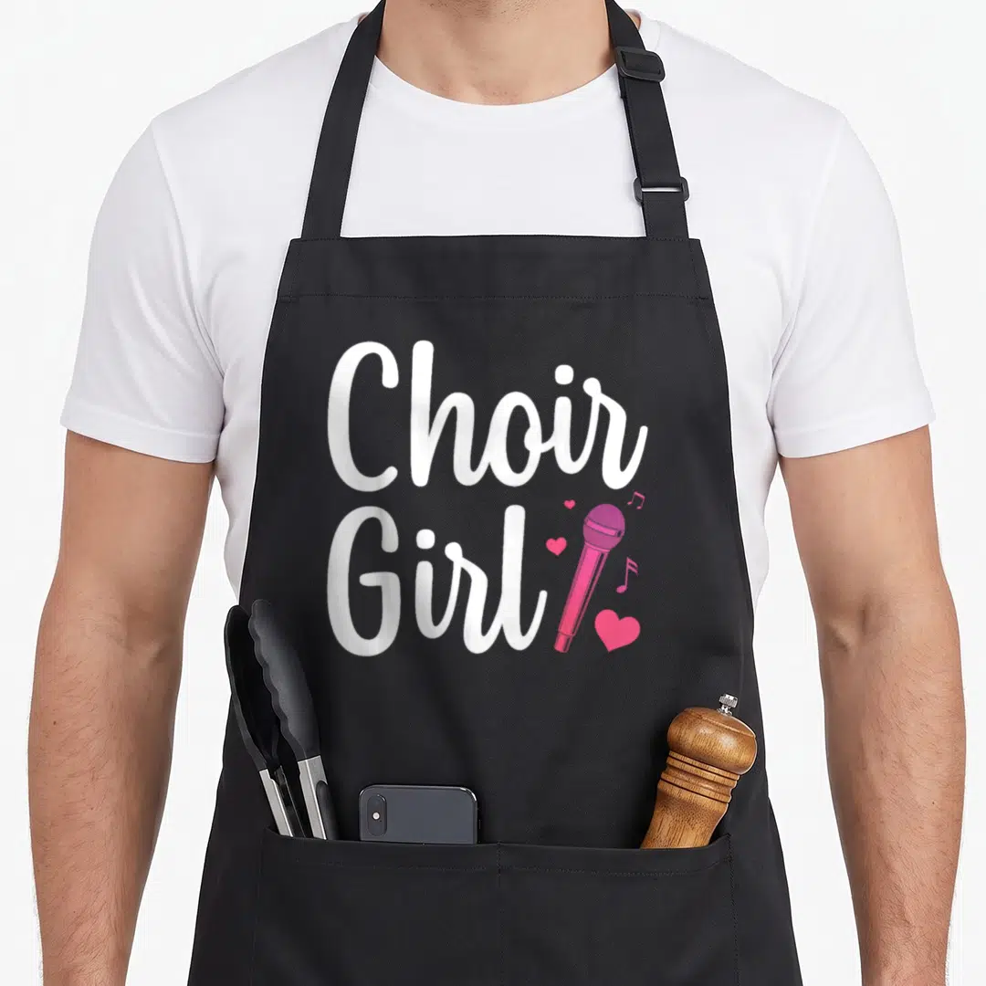 Choir singing chorus apron - Stacked white Choir Girl text beside pink microphone, hearts, and musical notes — shown on a black cotton canvas apron against a white background
