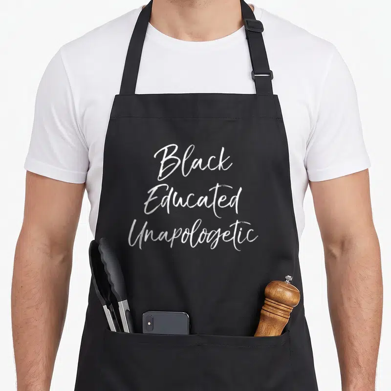 Educated unapologetic apron - White script text reading Black Educated Unapologetic stacked vertically — shown on a black cotton canvas apron against a white background