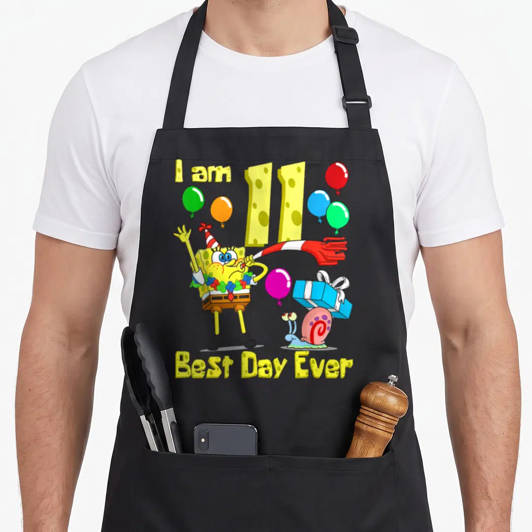 Retro age birthday apron for grilling - SpongeBob holding a party blower with balloons and text I am 11 Best Day Ever — shown on a black cotton canvas apron against a white background